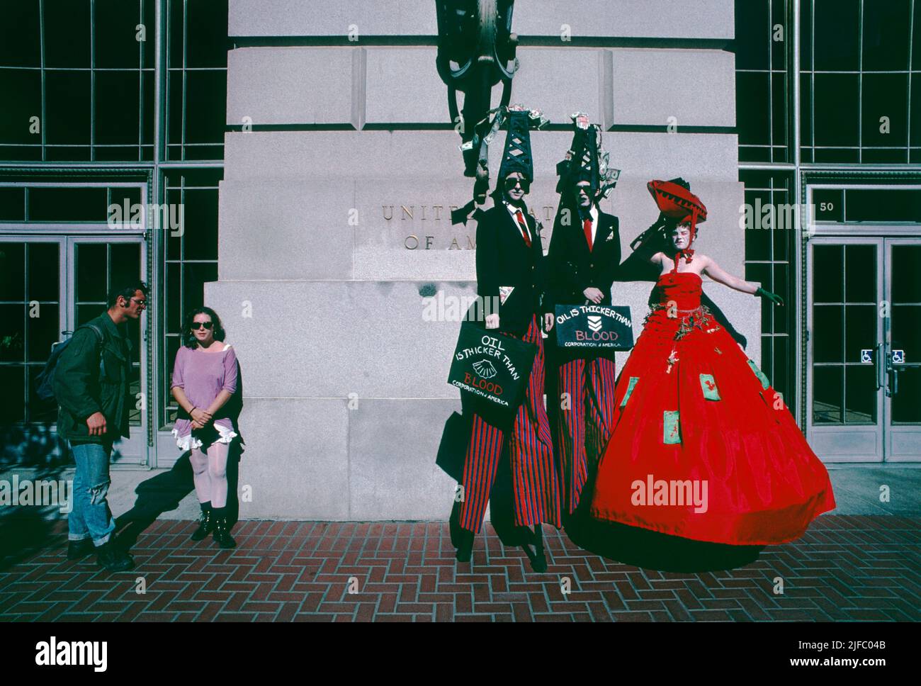 Performance artists on stilts protesting Oil companies and the United States military in the Middle East during the Persian Gulf crisis.  The demonstrators, dressed as “big Oil” executives wore oil derricks spewing blood stained U.S. dollars, stood outside the U.S. Federal Building on the Civic Center Plaza in Central San Francisco, California in October 1990. Stock Photo