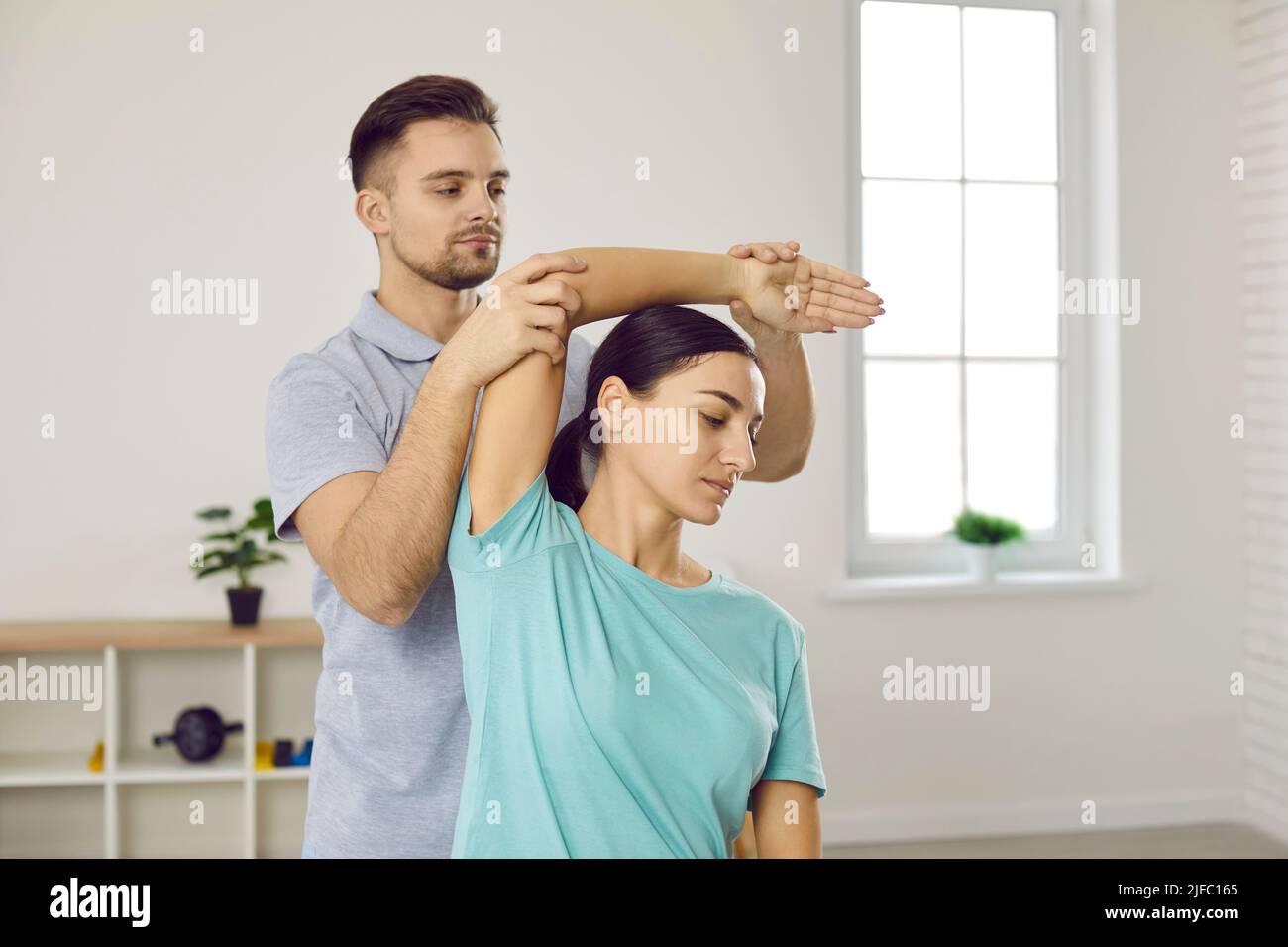 Male physiotherapist help patient with arm recovery Stock Photo