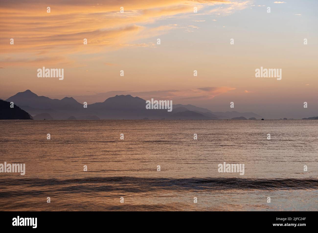 view of the sea and mountains in the distance at dawn. Stock Photo