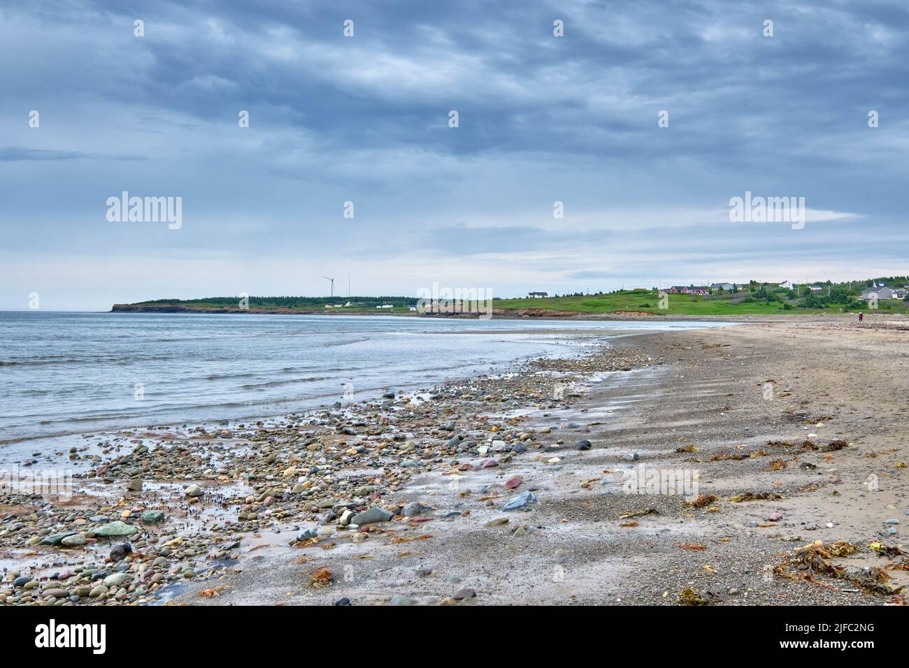 Photograph of a rocky ocean floor at low tide near the shore of Glace Bay Beach. The photo is lookin back towrds the Town of  Big Glace Bay. Stock Photo