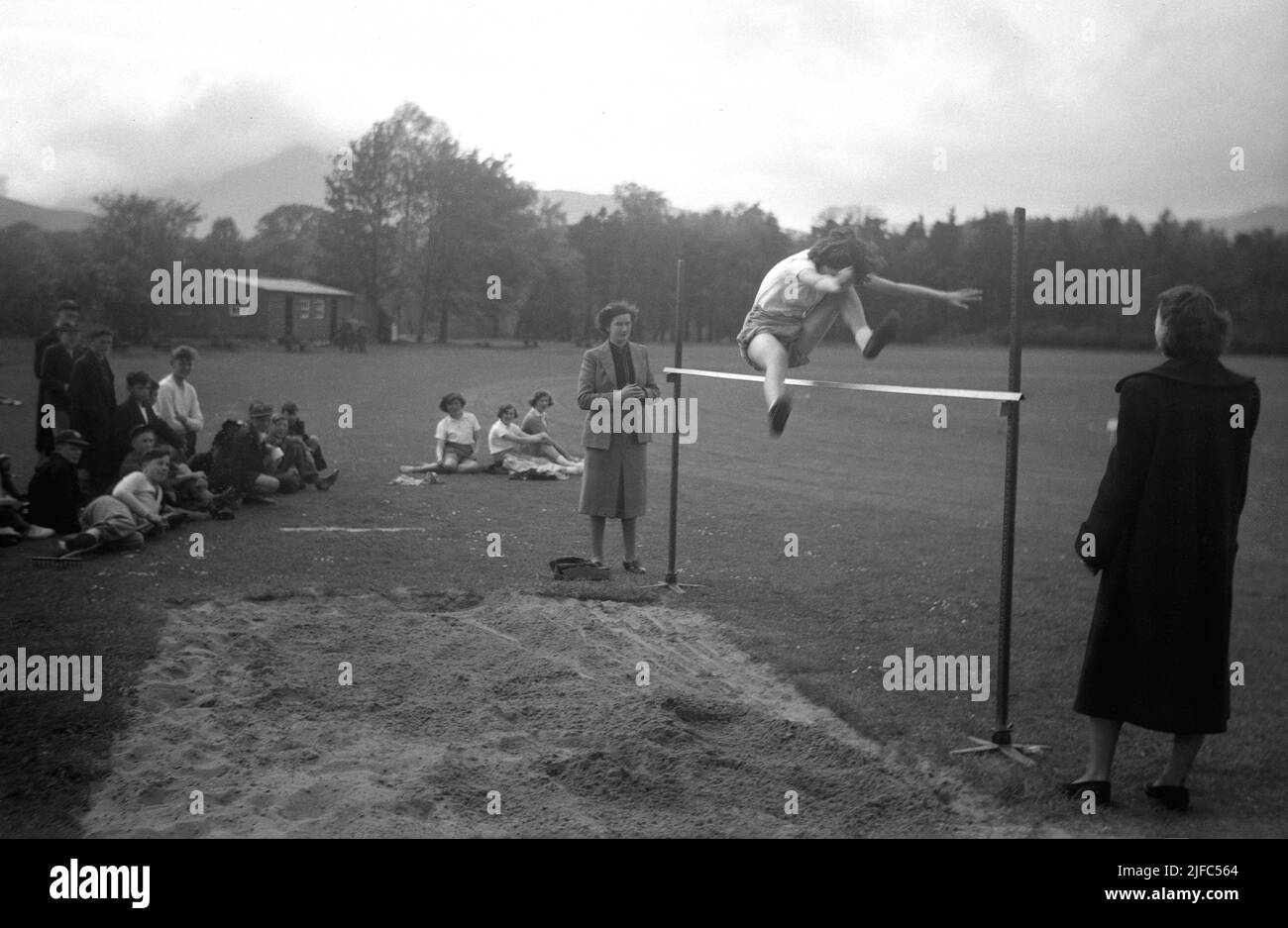 1954, historical, outside in a section of a large field, a girl doing