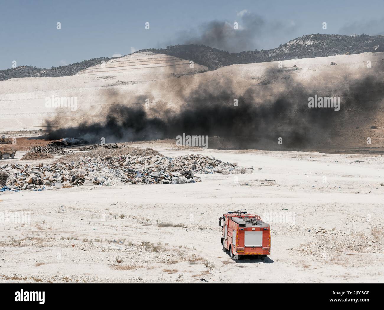 Fire in a tire dump. Heavy black smoke from burning old tires Stock Photo