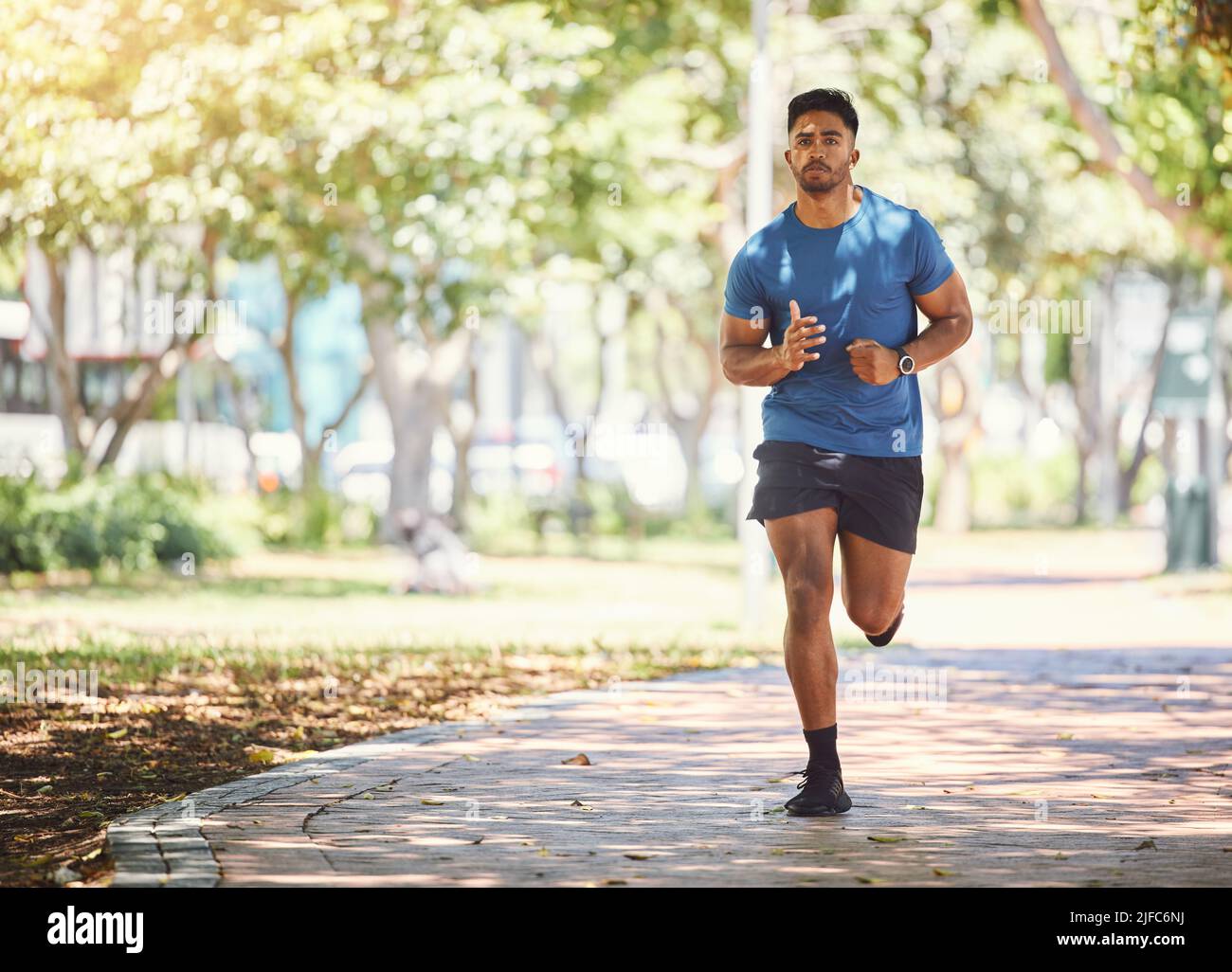 One active young indian man exercising outdoors. Handsome male athlete enjoying a jog or run for