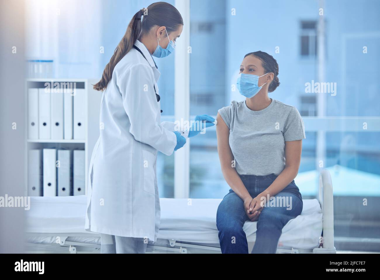 Doctor sterilise the arm of patient with cotton. Doctor wiping a patients arm for injection. Doctor about to inject patient with covid cure Stock Photo