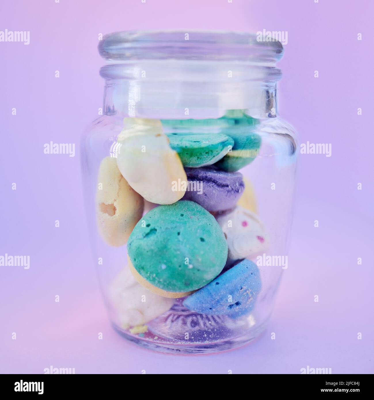 https://c8.alamy.com/comp/2JFC84J/a-closeup-of-a-glass-jar-filled-with-a-variety-of-colourful-painted-little-beach-stones-isolated-against-a-purple-background-a-good-little-concept-of-2JFC84J.jpg