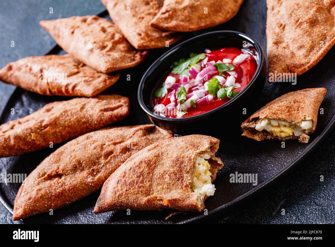 fried empanadas, hand pies with hard boiled egg fillings on black