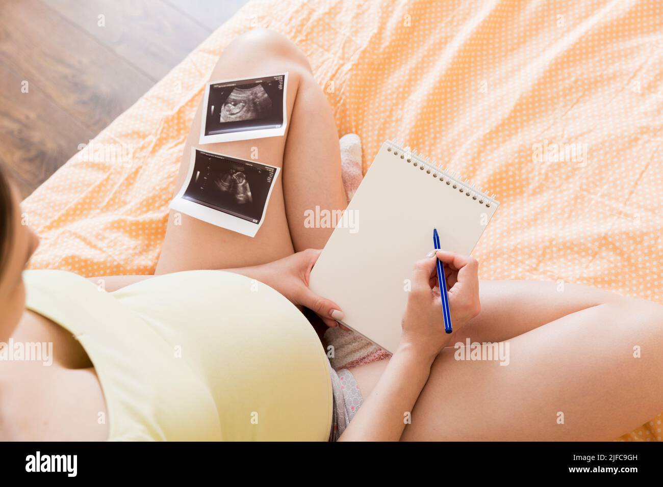 Maternity Writing Top view caring future mother writing diary with ultrasound. pregnant ...