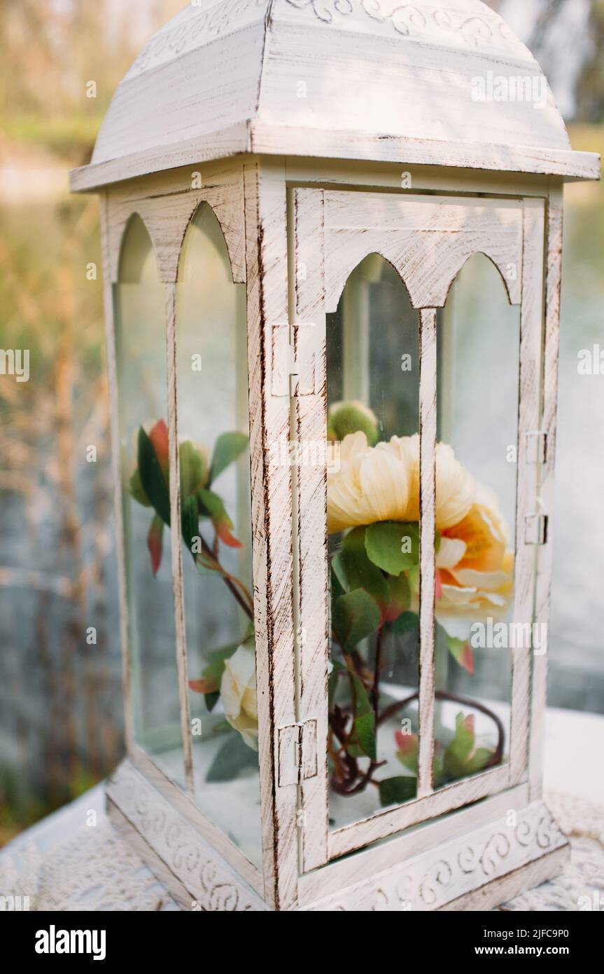 Vintage lantern with beautiful flowers close-up Stock Photo
