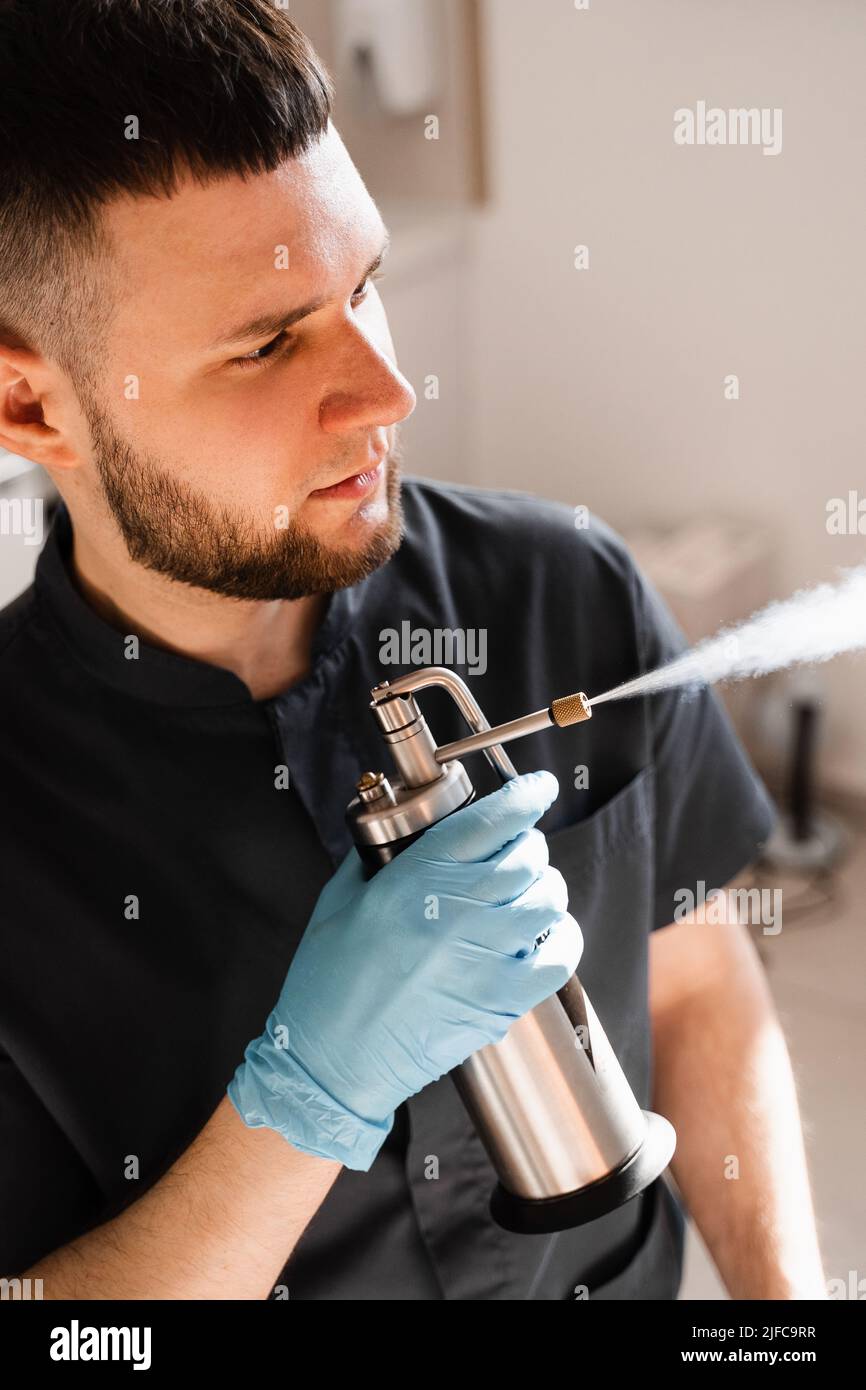 ENT doctor spray nitrogen for cryo therapy. Procedures of for mucosal renewal and treatment of chronic pharyngitis and tonsollitae. Doctor otolaryngol Stock Photo