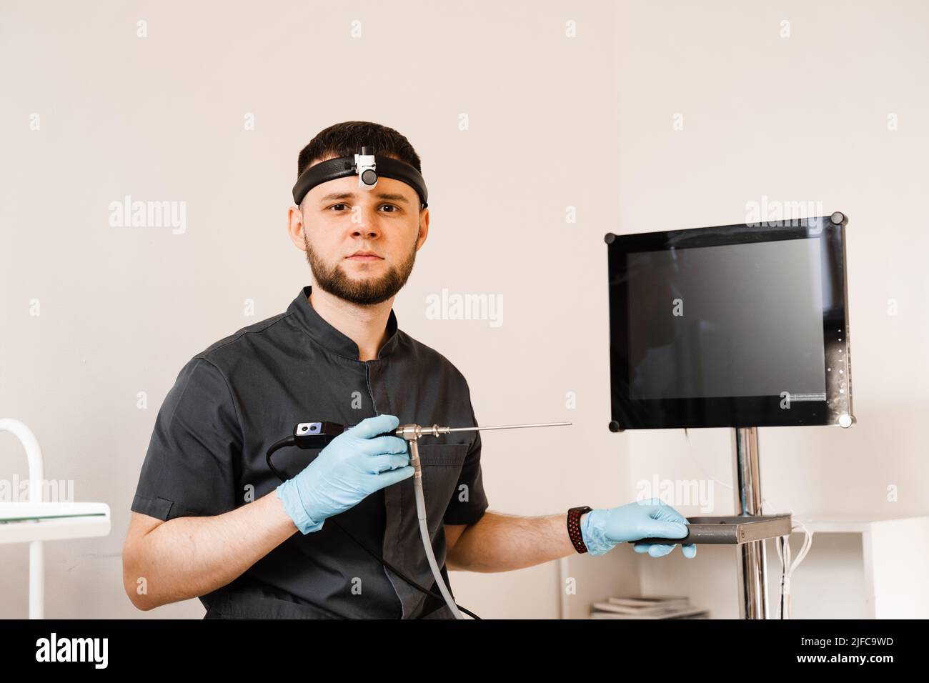 ENT doctor otolaryngologist with endoscope in hands. Prepearing for