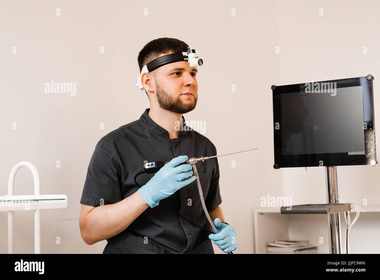 ENT doctor otolaryngologist with endoscope in hands. Prepearing for