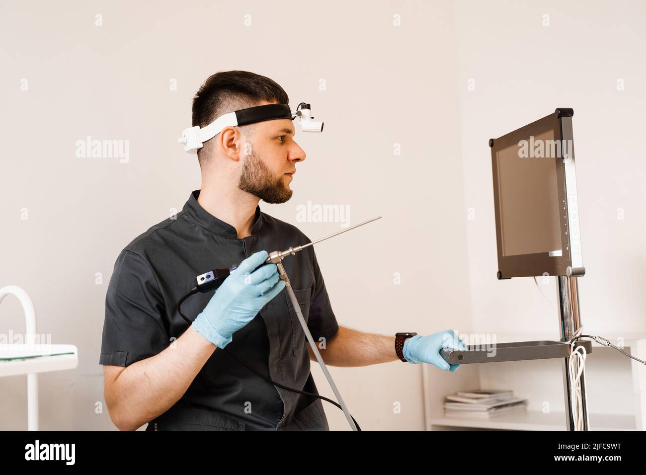 ENT doctor otolaryngologist with endoscope in hands. Prepearing for endoscopy procedure. Doctor
