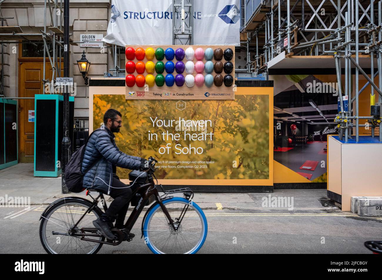 London, UK. 1 July 2022. A construction site in Golden Square decorated  with hard hats for Pride ahead of Pride in London which takes place on 2  July. The Gay Liberation Front (