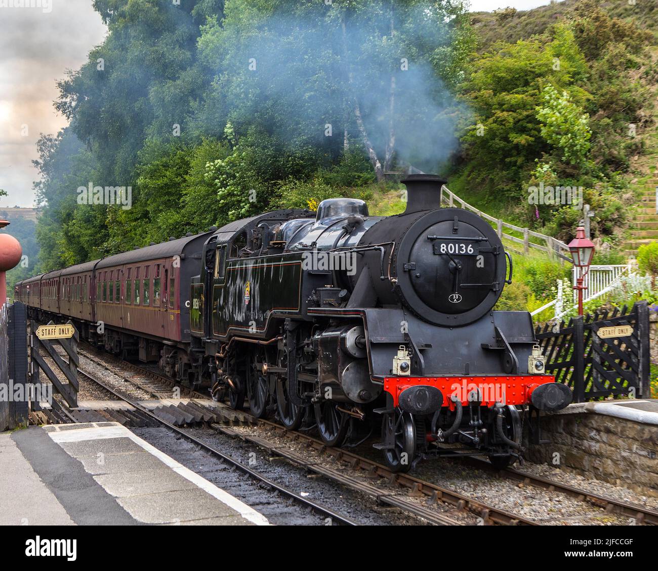 Goathland, UK - June 9th 2022: A classic steam train of the North Yorkshire Moors Railway, pulling into Goathland Railway Station in North Yorkshire, Stock Photo
