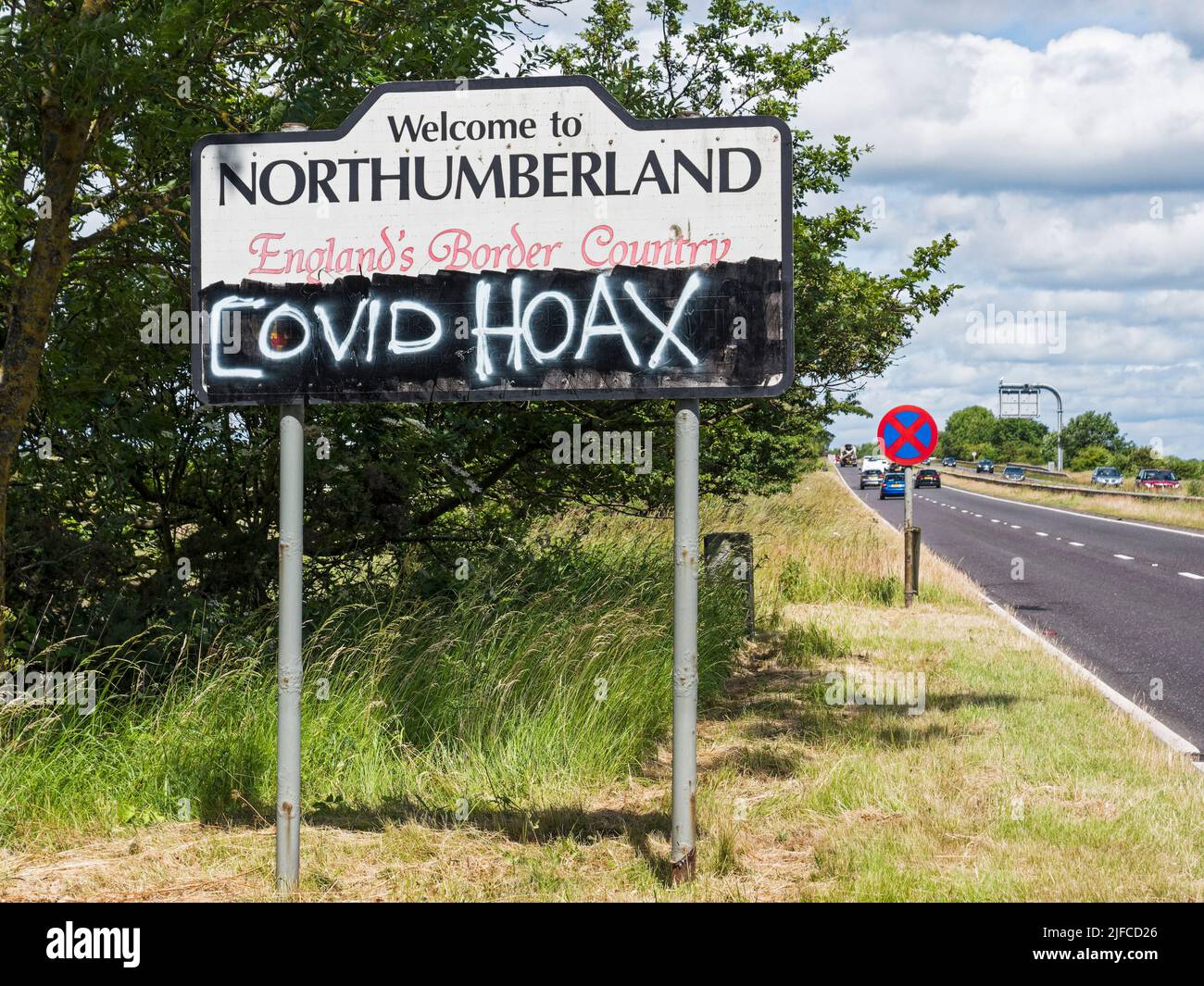 Covid hoax graffiti on a UK road sign. Stock Photo