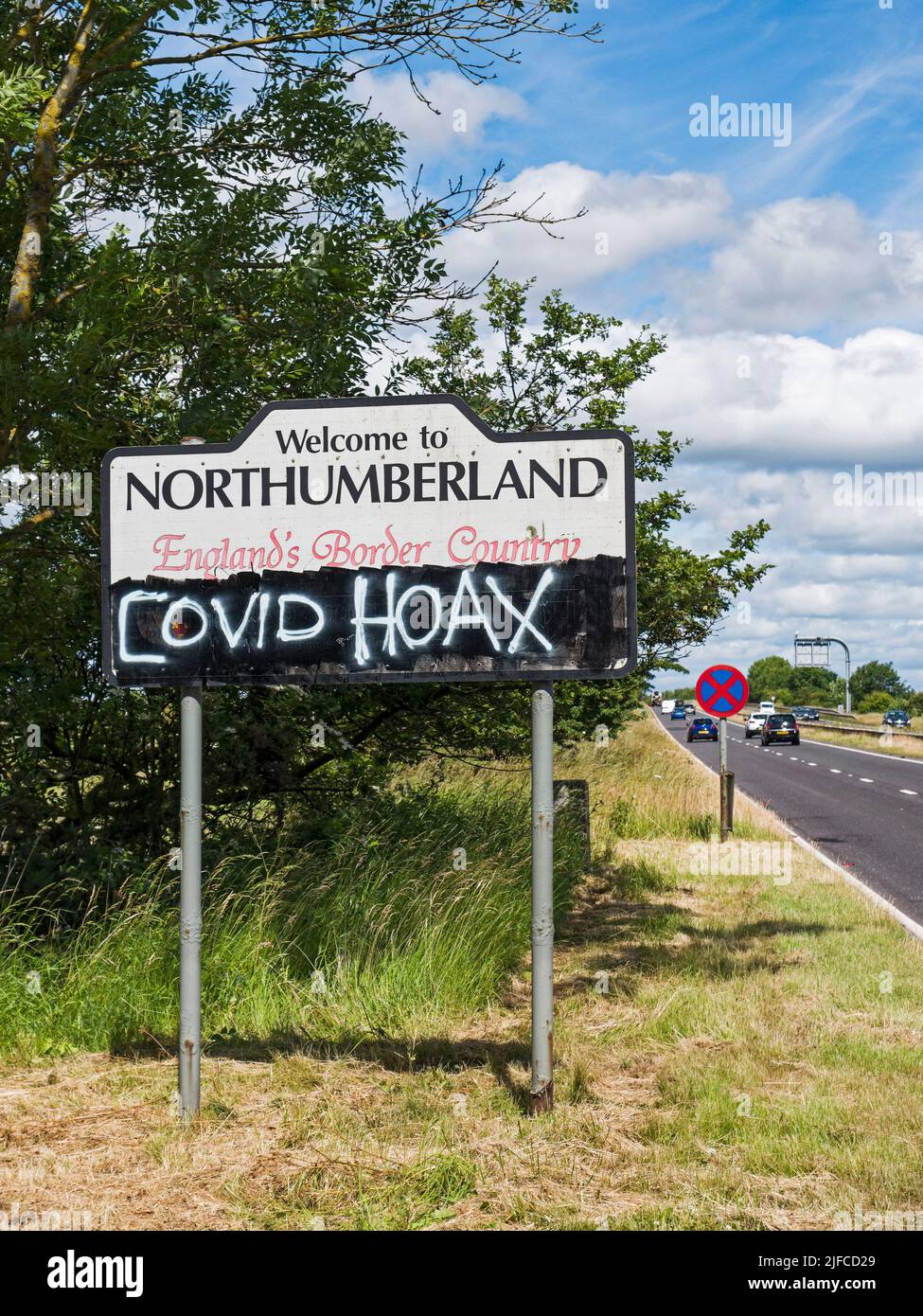 Covid hoax graffiti on a UK road sign. Stock Photo