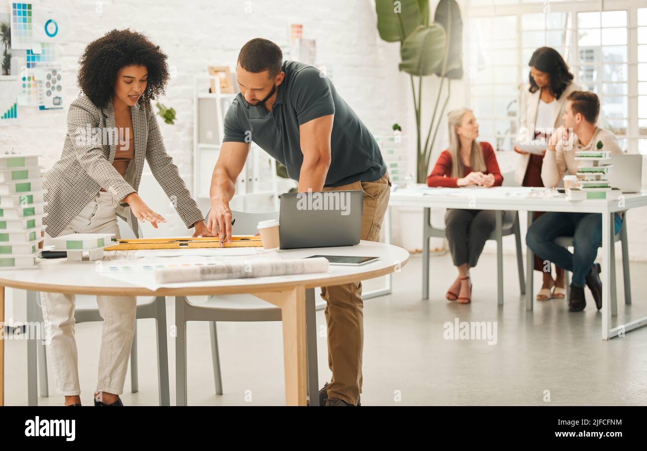 Diverse businesspeople working together. Team of architects working in an office together. Businesspeople collaborate on a building project. Coworkers Stock Photo