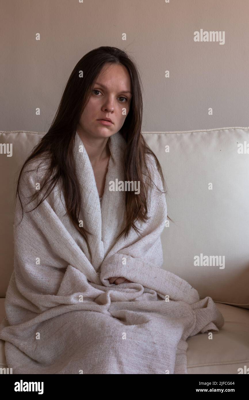 Sad tired woman sitting on a sofa Stock Photo