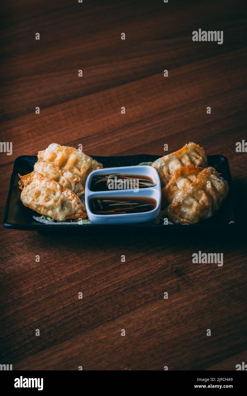 A plate of freshly made Jiaozi dish served with soy sauce and cabbage