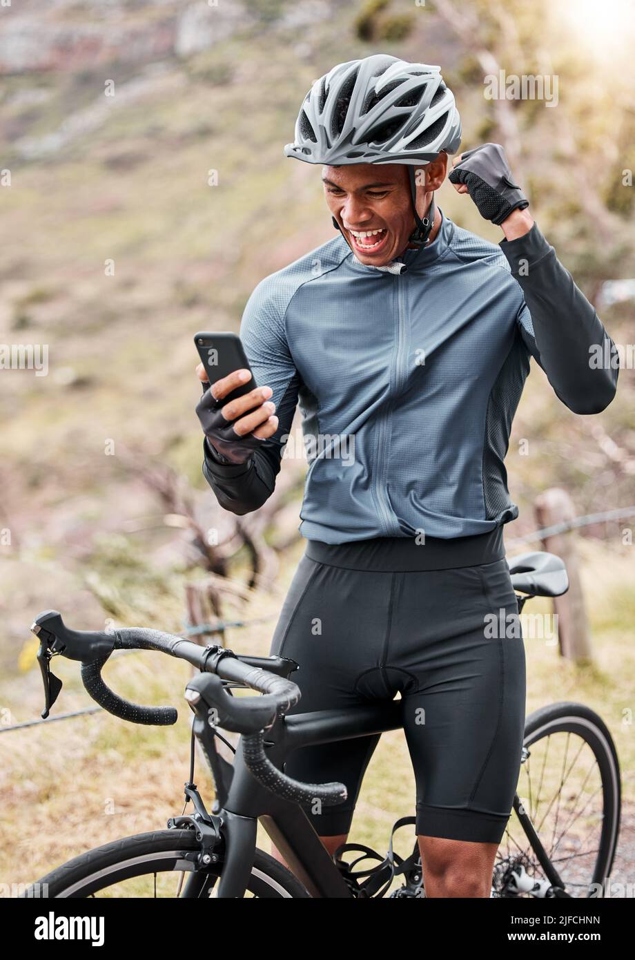 African American Cyclist Wearing A Helmet While Using A Cellphone And african-american-cyclist-wearing-a-helmet-while-using-a-cellphone-and