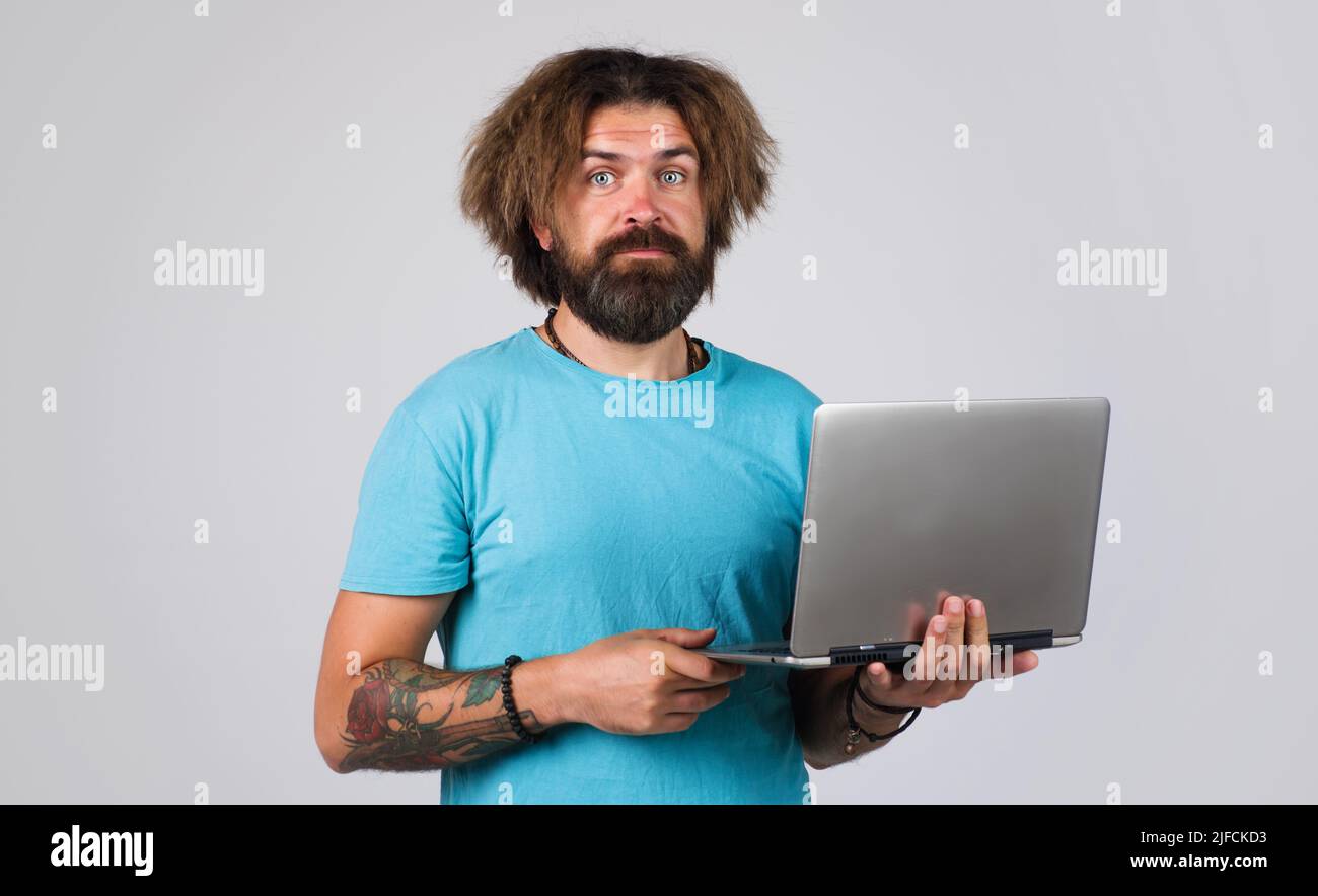 Bearded man in t-shirt with laptop computer. Education, studying and student life. Stock Photo