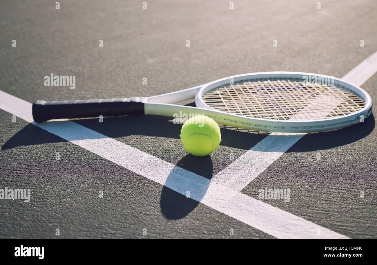 Above shot of a tennis racquet and tennis ball on a sports court. The only tools a professional tennis player needs to participate in their chosen Stock Photo