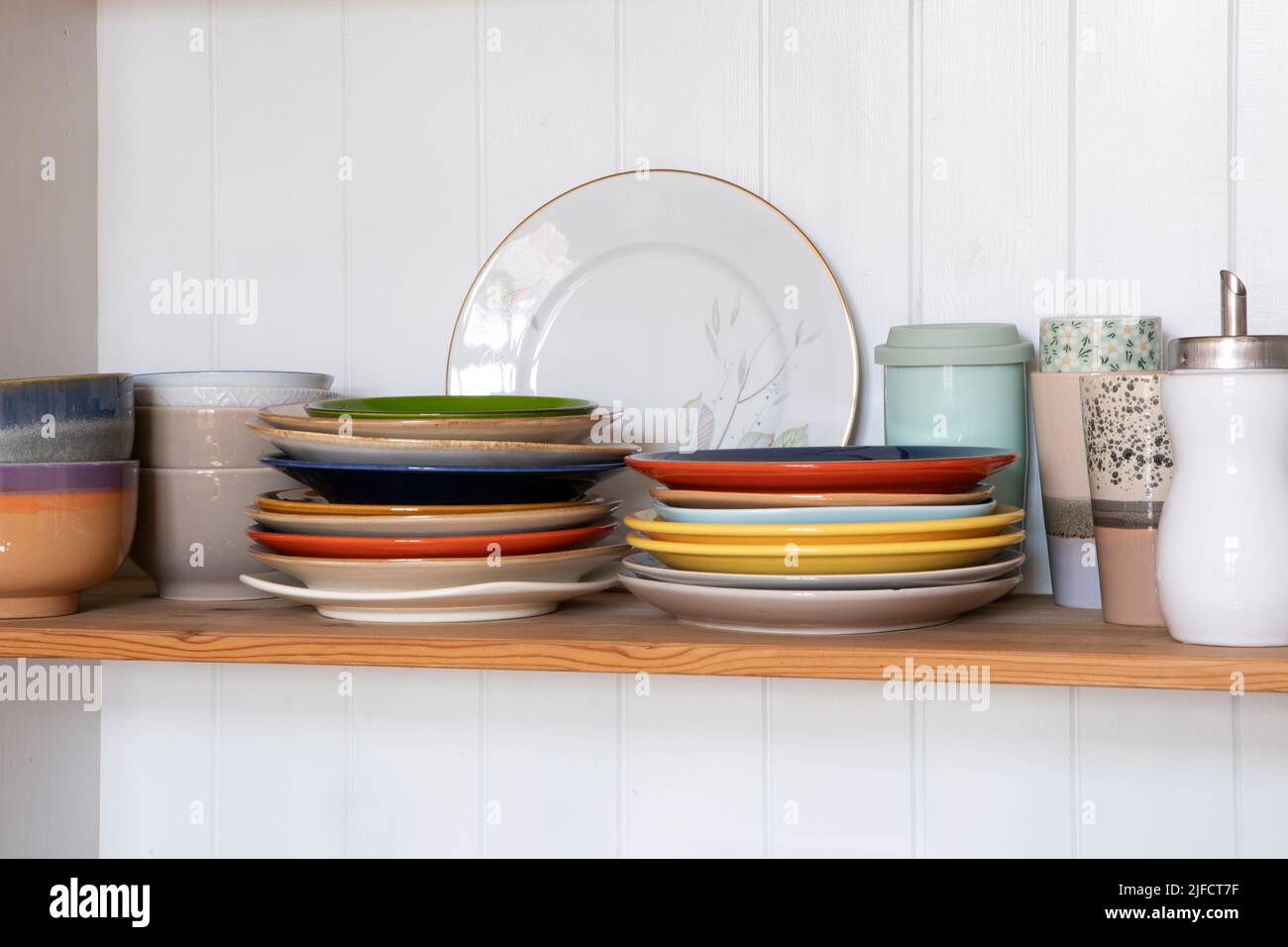 Wooden shelf with kitchen utensils, rustic style. Tableware, plates and