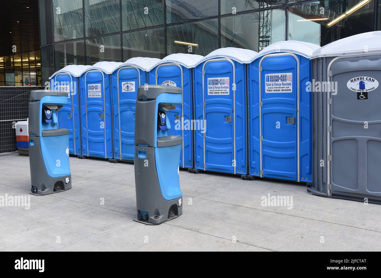 Portable toilets and wash stations (foreground) outside Rogers Arena in Edmonton. Alberta, Canada Stock Photo