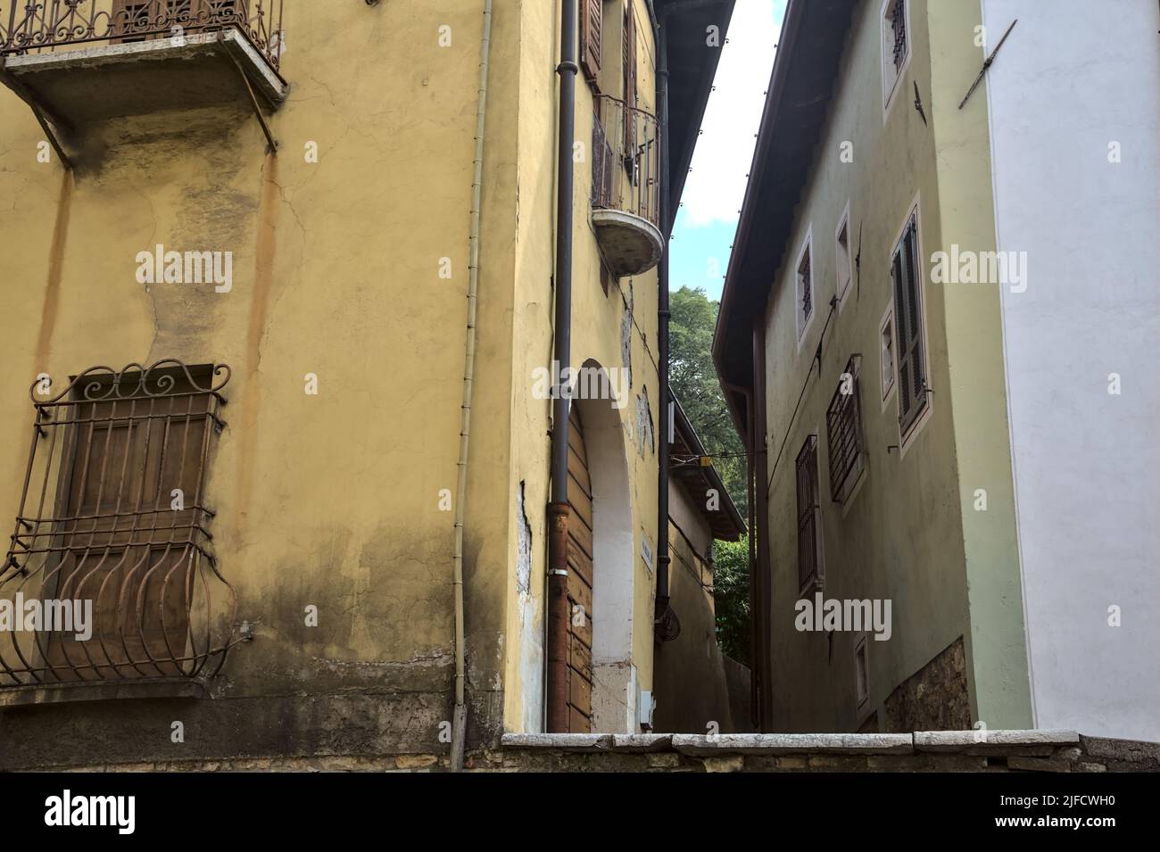 Alley between tall buildings seen from below Stock Photo - Alamy