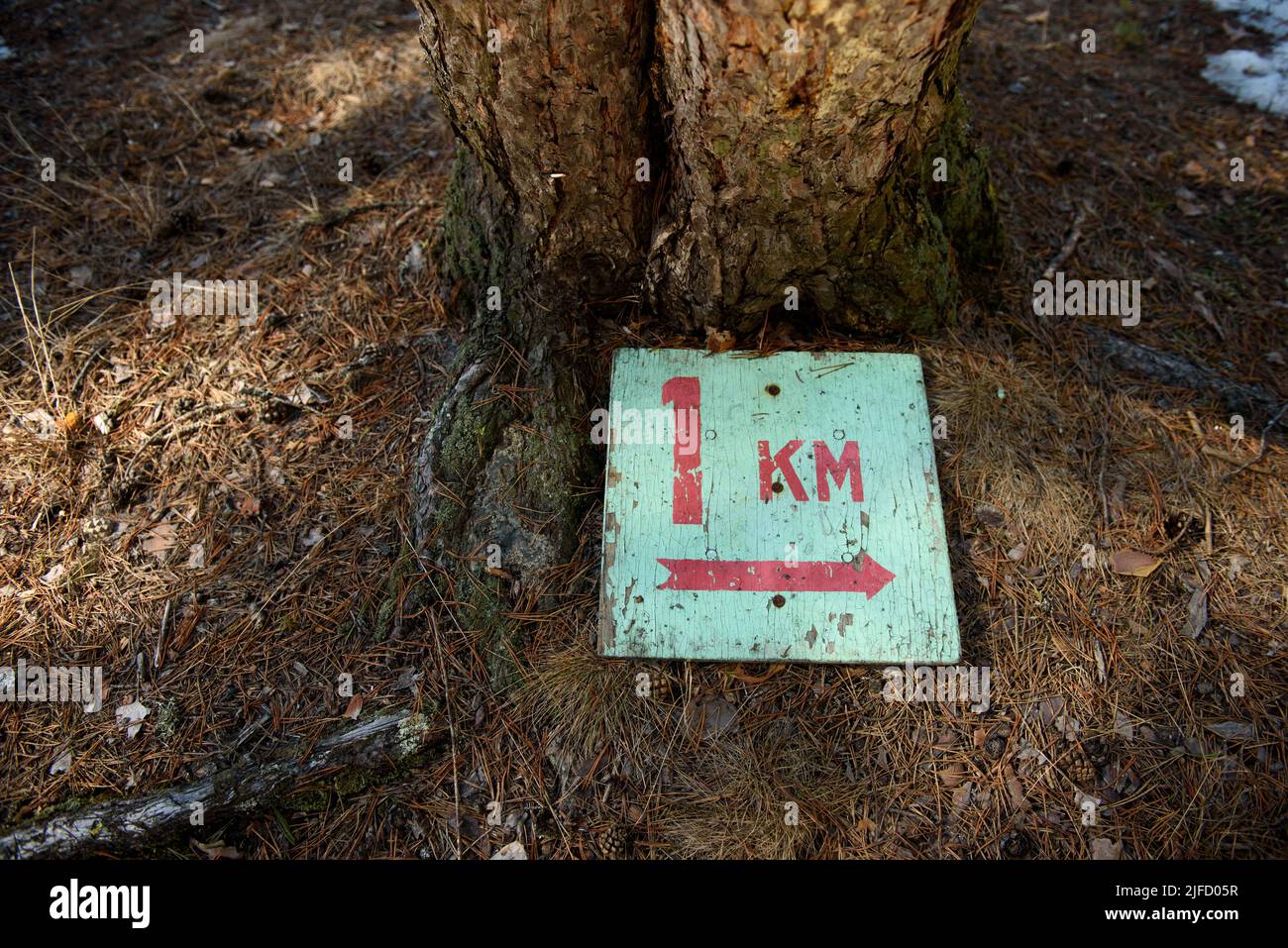 A sign indicating the length of the tourist route 1 kilometer lying on ...