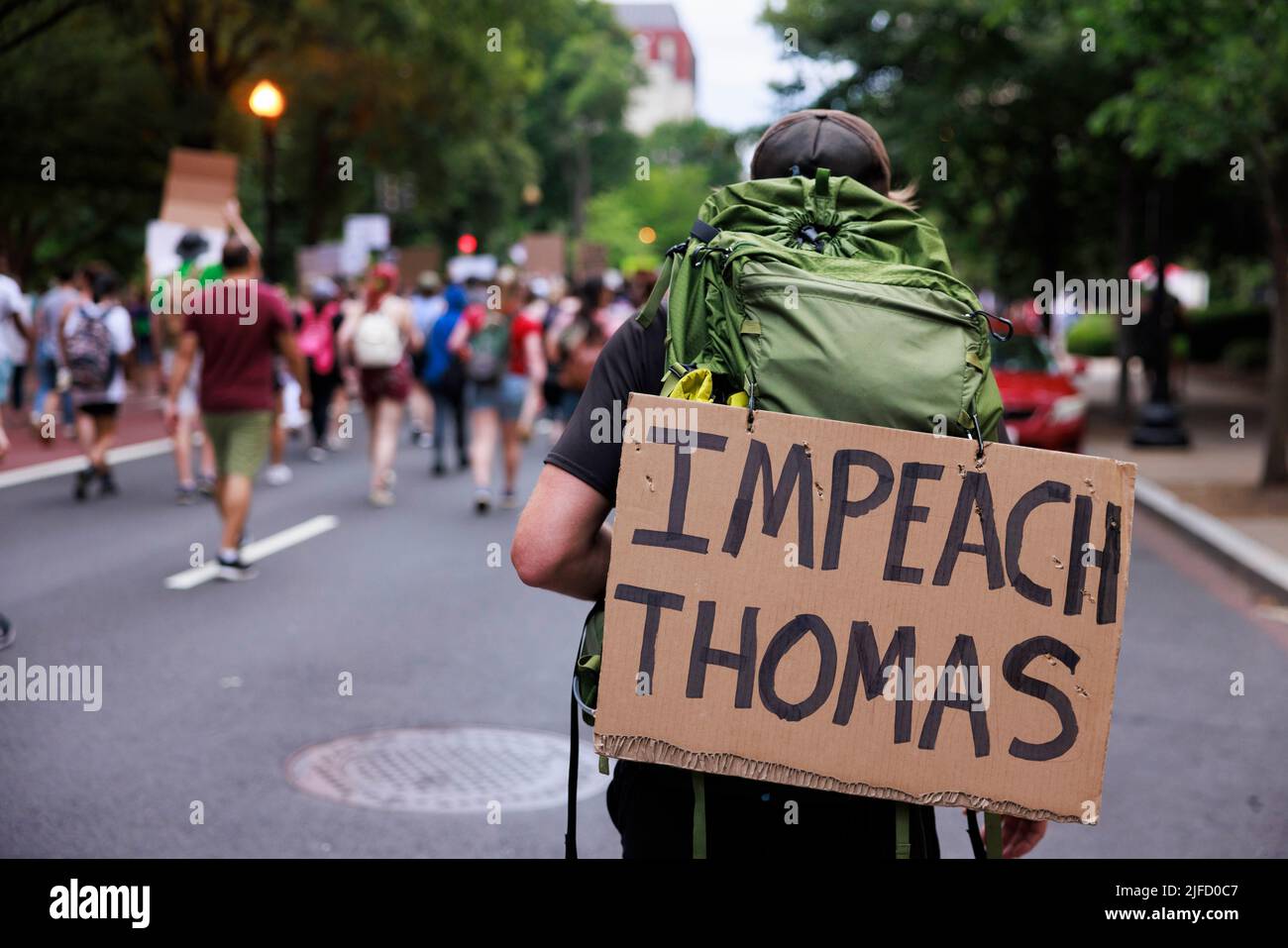WASHINGTON, DISTRICT OF COLUMBIA - JUNE 26: An abortion-rights activist carrying a sign reading, “Impeach Thomas,” marches from the Supreme Court of the United States to the White House in protest two days after a conservative majority struck down Roe v Wade, on June 26, 2022 in Washington, District of Columbia. The Court's decision in Dobbs v Jackson Women's Health overturns the landmark 50-year-old Roe v Wade case and erases a federal right to an abortion. Stock Photo
