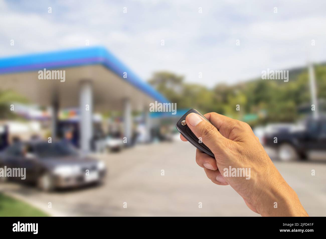 Hand holding car key isolated on a white background with blurred ...