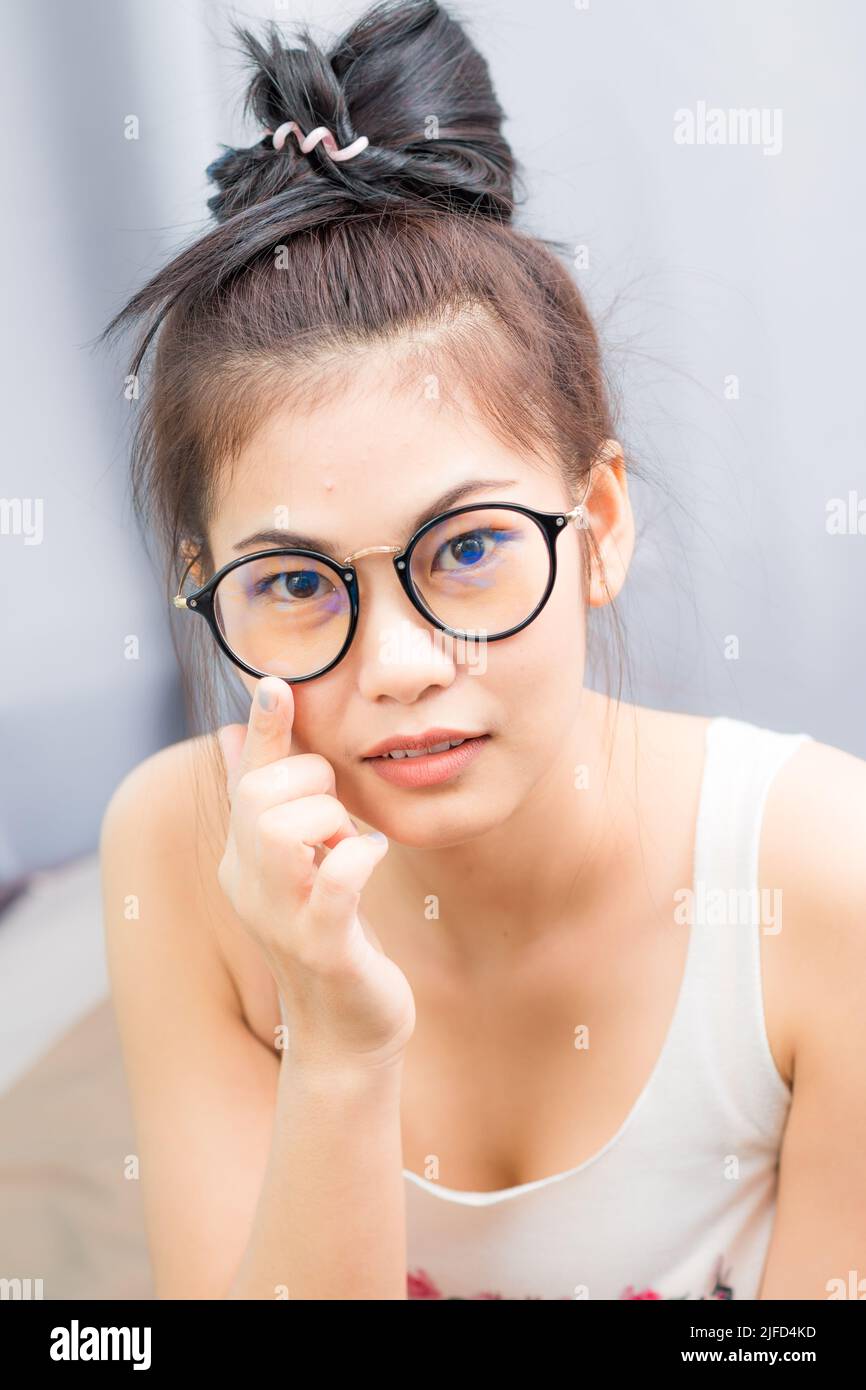 Pretty young asian women wear glasses in bed room portrait of beautiful ...