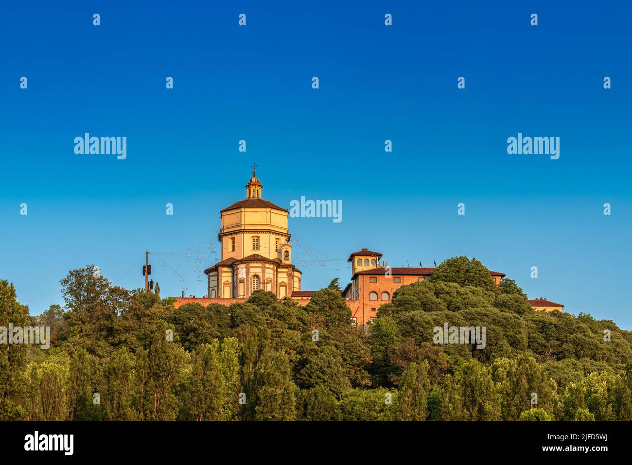 View of Santa Maria del Cappuccini Church on top of a hill surrounded by trees in Po riverbank Turin Italy Stock Photo