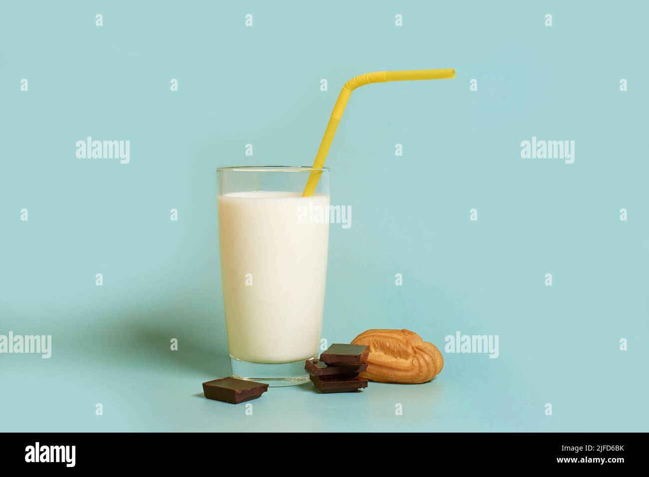 A glass of milk, plastic tube, a cake and pieces of dark chocolate  Stock Photo