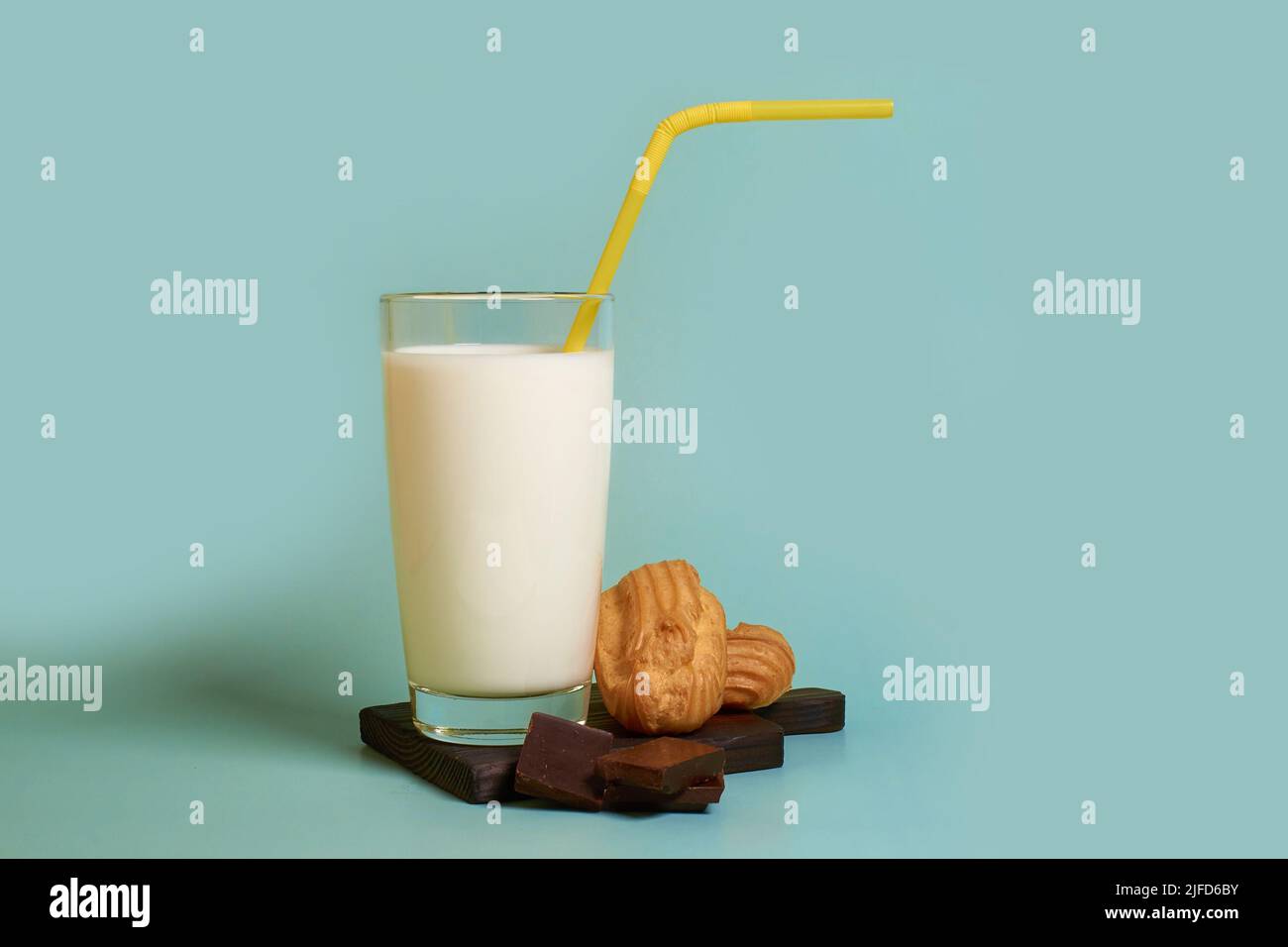 A glass of milk, cakes and pieces of dark chocolate on a wooden stand  Stock Photo