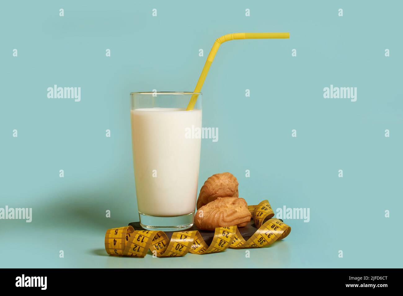 A glass of milk, plastic tube, tailor 's meter and cakes  Stock Photo