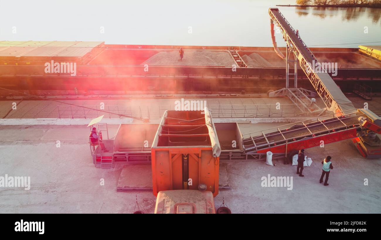 Grain loading to cargo ship. Port grain elevator. Industrial sea trading port bulk cargo zone grain terminal Stock Photo