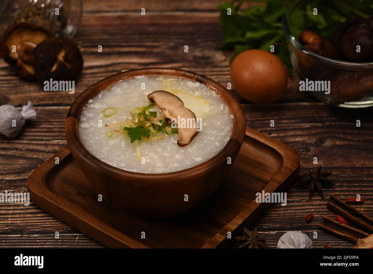 Bowl of rice porridge with soft boiled egg, shiitake mushroom, slice ginger and scallion for breakfast Stock Photo