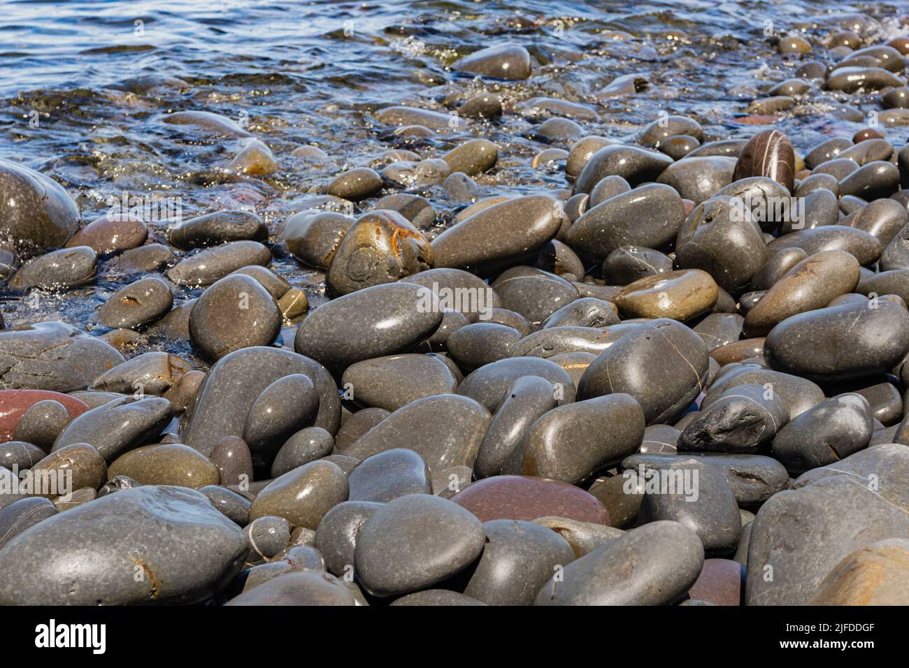 Greencliff Beach, Colourful, Detailed View With Waters Edge and Wet Pebbles, Exposed at Mid Tide: Greencliff, Near Bideford, Devon Stock Photo