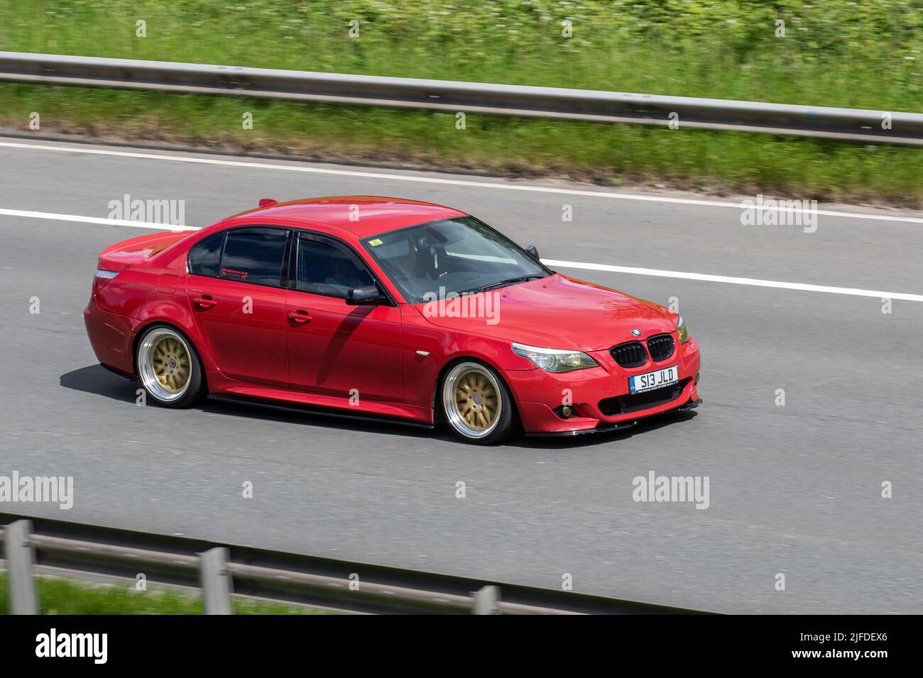 Custom 2008 red BMW 530D M Sport Auto Diesel saloon 2993 cc; driving on the M6 Motorway, Manchester, UK Stock Photo