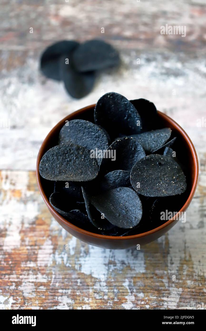 Black food. Black chips. Black food trend. Cuttlefish ink food. Stock Photo