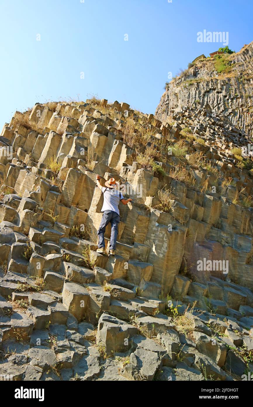 Traveler Climbing the Symphony of Stones, Massive Basalt Rock Formations Along the Garni Gorge in Armenia Stock Photo