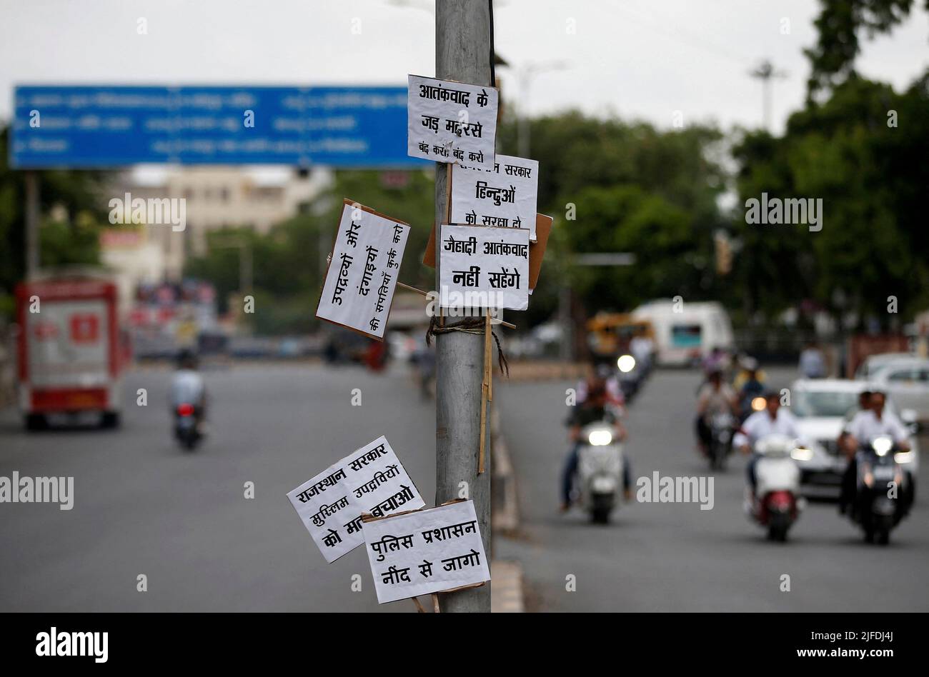 Placards are seen tied to a pole during restrictions imposed by authorities after the killing of Kanhaiya Lal Teli, a Hindu tailor, carried out by two suspected Muslim men who filmed the act and posted it online, in Udaipur, in the northwestern state of Rajasthan, India, July 1, 2022. The placards read: 'Shut down terrorism-breeding madrasas', 'Auction properties of rioters and trouble mongers', Will not tolerate jihadi terrorism', 'Rajasthan government, don't protect Muslim miscreants' and 'Wake up police administration'. REUTERS/Amit Dave Stock Photo