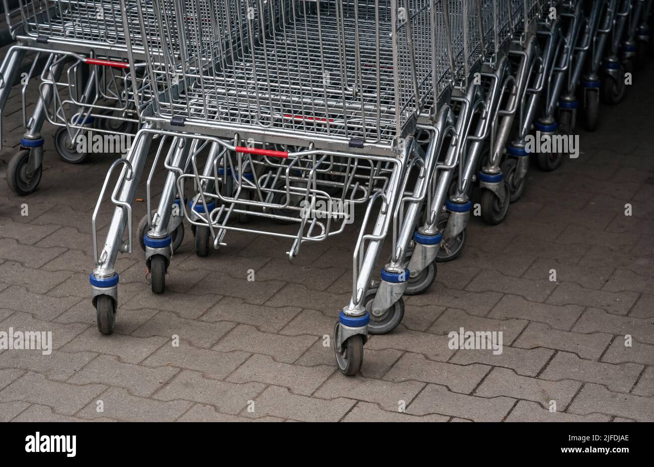 Closeup of metal shopping carts stacked in front shop mall, detail on