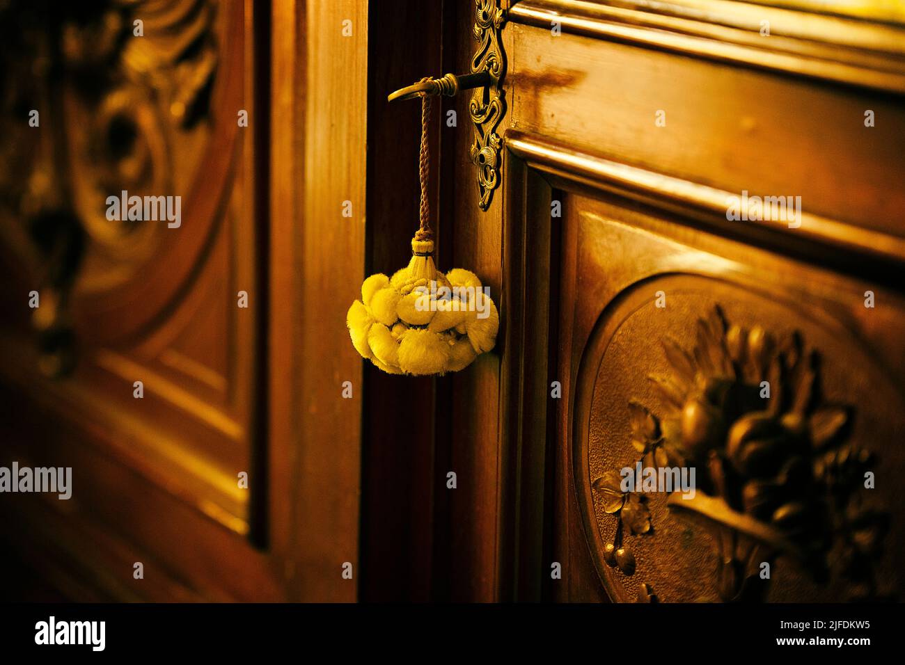 yellow tassel on carved wooden furniture Stock Photo Alamy