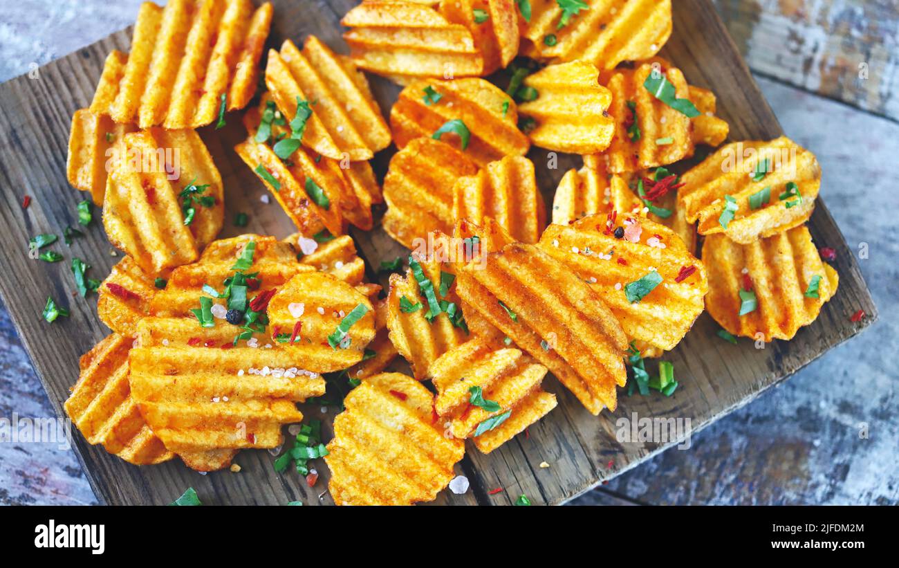 Chips with spices on a wooden surface. Unhealthy food. Highcalorie