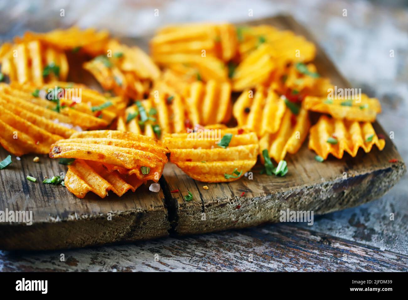 Chips with spices on a wooden surface. Unhealthy food. Highcalorie