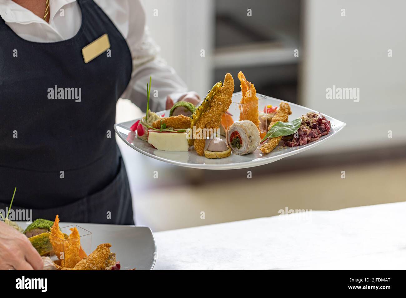 Waitress is carrying plates with starter dish Stock Photo