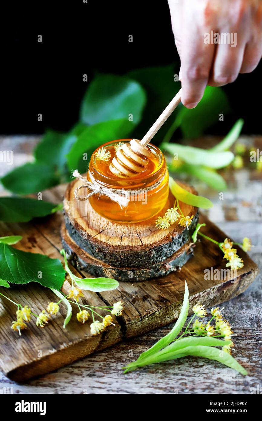 Linden honey in a jar. Leaves and flowers of linden. Freshly linden ...